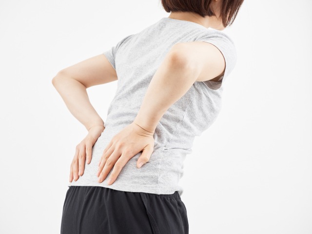 腰を押さえる女性